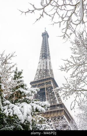 L'hiver à Paris dans la neige. Low angle view of la Tour Eiffel par couvert de neige des branches. Banque D'Images