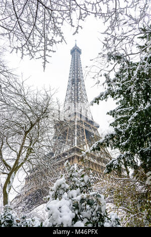 L'hiver à Paris dans la neige. Low angle view of la Tour Eiffel par couvert de neige des branches. Banque D'Images