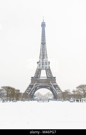 La Tour Eiffel sur un jour d'hiver à Paris vu depuis le Champ de Mars avec une pelouse couverte de neige au premier plan. Banque D'Images