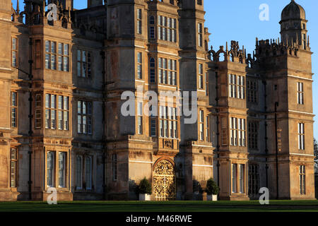 Coucher de soleil sur l'élévation ouest et le Golden Gate, Burghley House, manoir élisabéthain Cambridgeshire, Angleterre, RU Banque D'Images