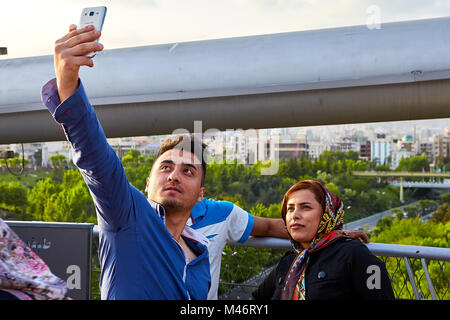 Téhéran, Iran - 28 Avril 2017 : couple iranien - femme en hijab et l'homme - faire photo sur smartphone. Banque D'Images