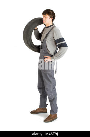 Un jeune contremaître brunet dans le travail uniforme gris avec roue noire. Banque D'Images