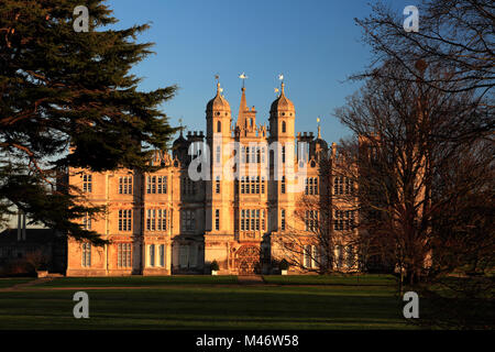 Coucher de soleil sur l'élévation ouest et le Golden Gate, Burghley House, manoir élisabéthain Cambridgeshire, Angleterre, RU Banque D'Images