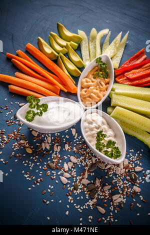 Assortiment de légumes frais avec dips sur fond bleu Banque D'Images