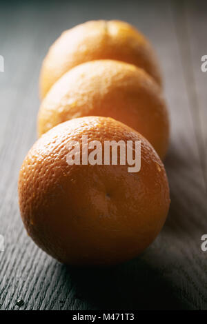 Trois oranges frais mûrs sur table en bois de chêne Banque D'Images