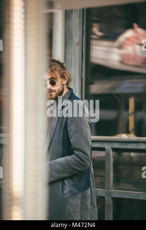 Portrait d'un homme barbu élégant vêtu d'enduire la marche à l'extérieur sur une rue de la ville Banque D'Images
