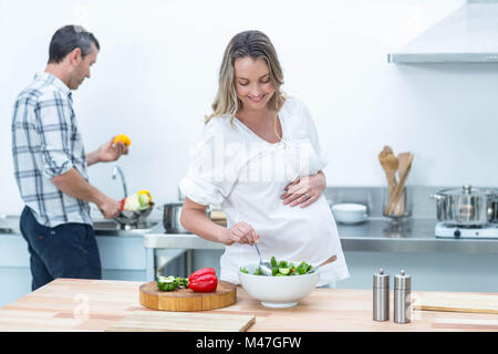 Femme enceinte faire une salade dans la cuisine Banque D'Images