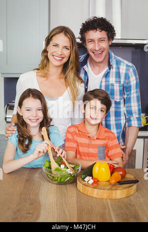 Portrait de famille heureuse de préparer une salade de légumes Banque D'Images