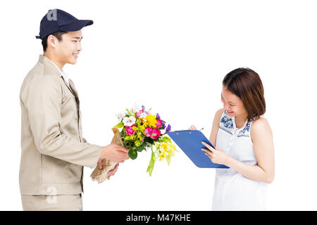 L'homme prenant livraison signature de femme tout en offrant des fleurs Banque D'Images