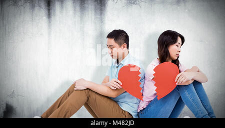 Image composite de triste couple holding cœur brisé pièces Banque D'Images