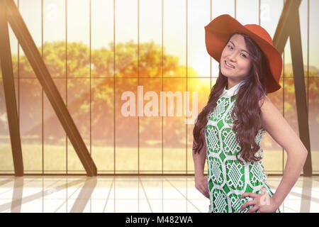 Composite image of asian woman with hat posing for camera Banque D'Images