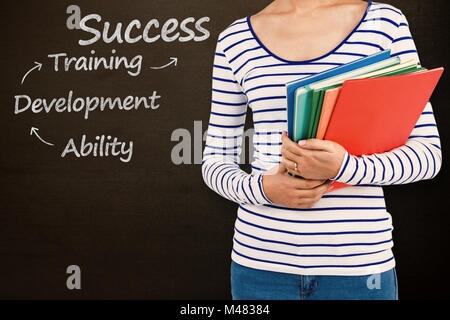 Image composite de mid section of woman holding files Banque D'Images