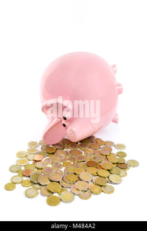 Lying pink piggy bank with pile de pièces en euros Banque D'Images