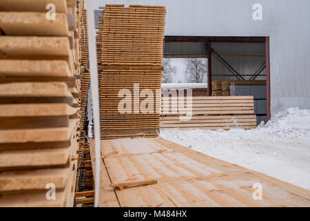 À scierie. Conseils scolaires à l'extérieur en hiver empilés Banque D'Images