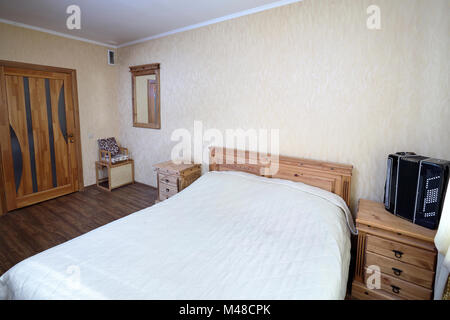 De l'intérieur de chambre à coucher maison rurale avec l'Accordéon sur table de nuit dans des tons pastel Banque D'Images