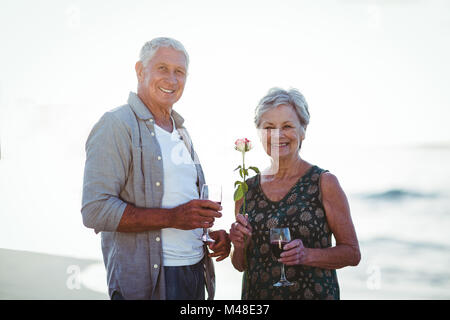 Senior couple holding rose et verres à vin rouge Banque D'Images