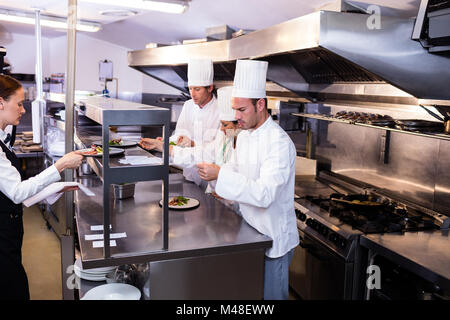 Chef de groupe de préparer des aliments en cuisine commerciale Banque D'Images