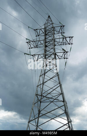 Poteau électrique les lignes électriques et les fils sur le verglas, omnious ciel. Pylônes à haute tension contre nuage pluvieux. Banque D'Images