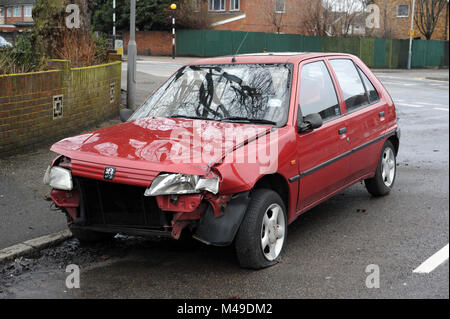 Peugeot rouge endommagée abandonnée dans une rue de Hayes, Middlesex Banque D'Images