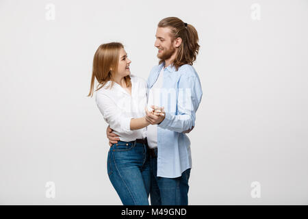 Jeune couple élégant en tissu occasionnels au cours de danse isolated on white background studio. Banque D'Images