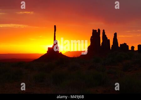 Lever du soleil à l'emblématique Monument Valley. Le soleil se lève derrière la création d'un totem lueur orange Banque D'Images