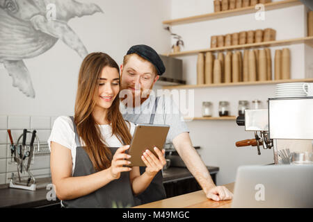 - Concept d'affaires Café sourire satisfait et quelques propriétaires d'oeil sur les tablettes des commandes en ligne dans un café moderne Banque D'Images