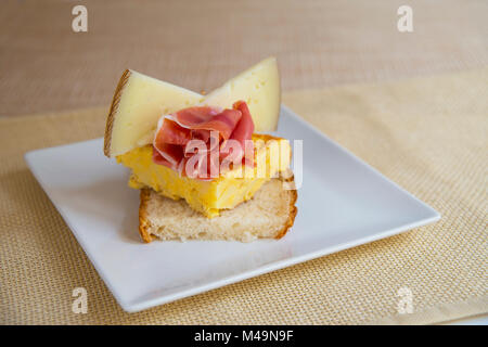 L'Espagnol tapa : fromage Manchego, jambon ibérique et de l'omelette espagnole sur toast. L'Espagne. Banque D'Images