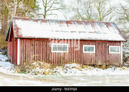 Ancienne grange en bois rouge et patiné ou agritourisme en hiver. Banque D'Images