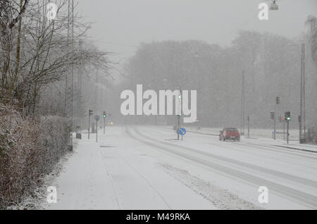 Le trafic de faible densité se déplaçant lentement, sur une route au cours d'importantes chutes de neige qui cause une réduction de la visibilité. Banque D'Images