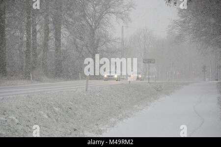 Le trafic de faible densité se déplaçant lentement, sur une route au cours d'importantes chutes de neige qui cause une réduction de la visibilité. Banque D'Images