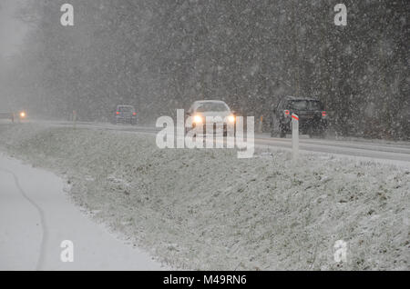 Le trafic de faible densité se déplaçant lentement, sur une route au cours d'importantes chutes de neige qui cause une réduction de la visibilité. Banque D'Images