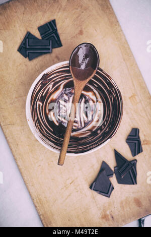 Le chocolat noir fondu et cuillère en bois sur un bol en céramique. Vintage filtre appliqué Banque D'Images