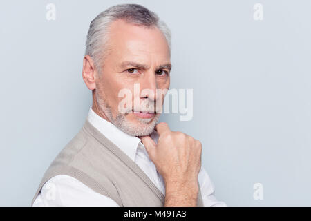 Close up portrait of intelligent faisant autorité réfléchie qualifié masculin viril vieille homme portant un gilet en tricot beige chemise blanche toucher menton wit Banque D'Images