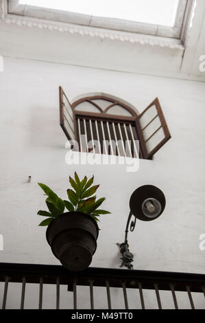 L'intérieur de la ville de pierre de Zanzibar Tanzanie café avec une fenêtre ouverte plante en pot et une lampe dans l'architecture traditionnelle arabe swahili Banque D'Images