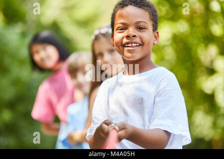 African boy et multiculturel groupe d'enfants en remorqueur de la guerre Banque D'Images