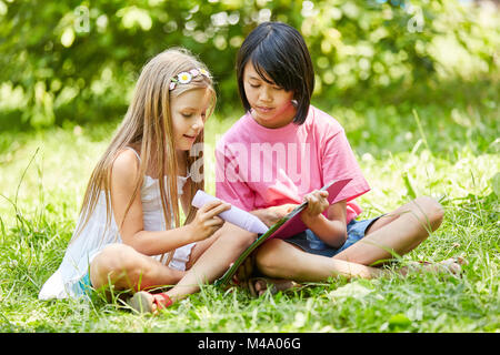 Deux filles ensemble un tableau avec de la craie à l'école élémentaire Banque D'Images