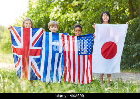 Groupe multiculturel des enfants comporte aussi les drapeaux des quatre grands états Banque D'Images