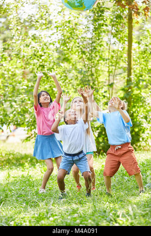 Groupe d'enfants joue avec globe en maternelle internationale Banque D'Images