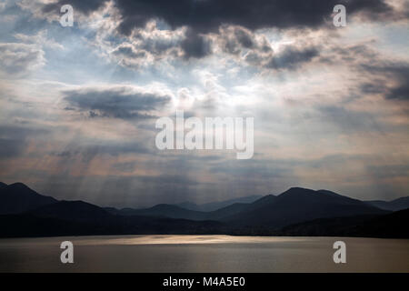 La formation de nuages spectaculaires de soleil,derrière des nuages sombres,atmosphère orageuse,Lago Maggiore,province de Verbano-Cusio-Ossola Banque D'Images