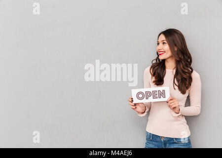 Demi-tour droit de blancs femme aux longs cheveux bruns holding sign avec Word ouvert, isolé sur fond gris copy space Banque D'Images