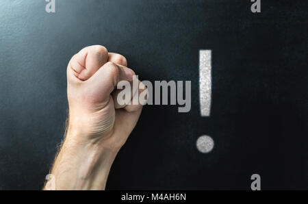 La discrimination, la discipline et le comportement à l'école. Mettre fin à l'intimidation. Fist en face d'un tableau. Tableau noir avec point d'exclamation. Banque D'Images