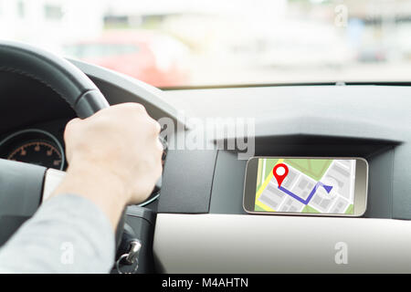 Location de voiture l'homme et à la navigation. En application mobile smartphone. Carte en ligne et application GPS sur l'écran du téléphone cellulaire. Vue aérienne de l'intérieur. Banque D'Images