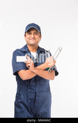 Heureux indiens auto mechanic en costume bleu et la tenue de l'outil clé dans l'action, isolé sur fond blanc Banque D'Images