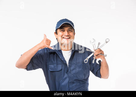Heureux indiens auto mechanic en costume bleu et la tenue de l'outil clé dans l'action, isolé sur fond blanc Banque D'Images