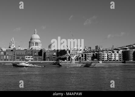 Bateau remorqueur chaland tirant le long de la rivière Thames, passant sous le pont du Millénaire, la Cathédrale St Paul en arrière-plan. Banque D'Images