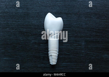 La prothèse dentaire repose sur une table en bois noir. Prothèse dentaire. Banque D'Images
