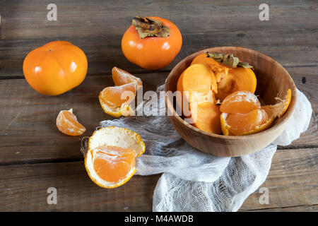 Le kaki et les tangerines fraîches fruits dans bol Banque D'Images