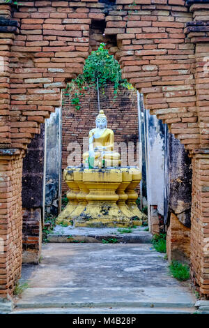 Une statue du Bouddha d'or est assis dans un petit sanctuaire en brique Inwa, ancienne capitale de la Birmanie Banque D'Images
