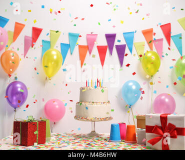 Gâteau d'anniversaire sur une table contre un mur avec des drapeaux et des ballons de décoration Banque D'Images