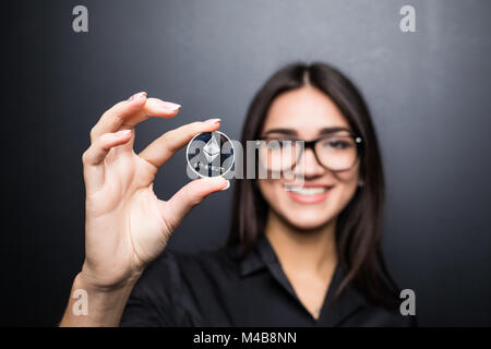 Femme d'affaires dans les verres avec Litecoin en mains isolé sur fond noir. Banque D'Images